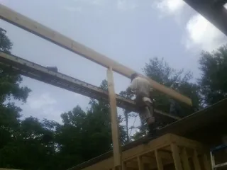 Carpenter setting a ridge beam over a new addition frame — Ice Dam Removal by Roofing Brothers in Menomonee Falls