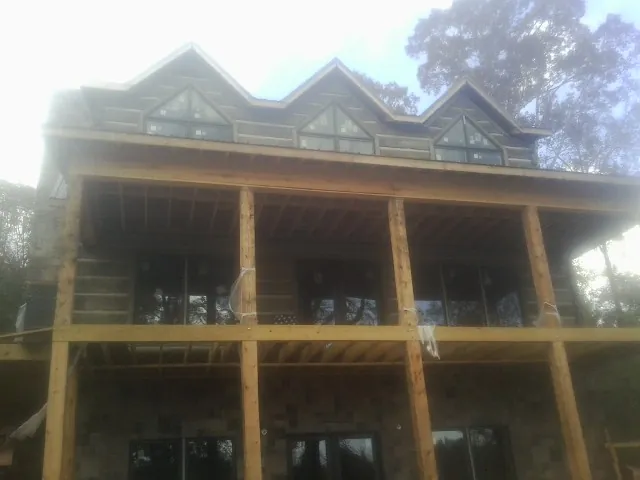 Dormers and porch framing on a large log home under construction — Roof Coating work by our crew in Menomonee Falls