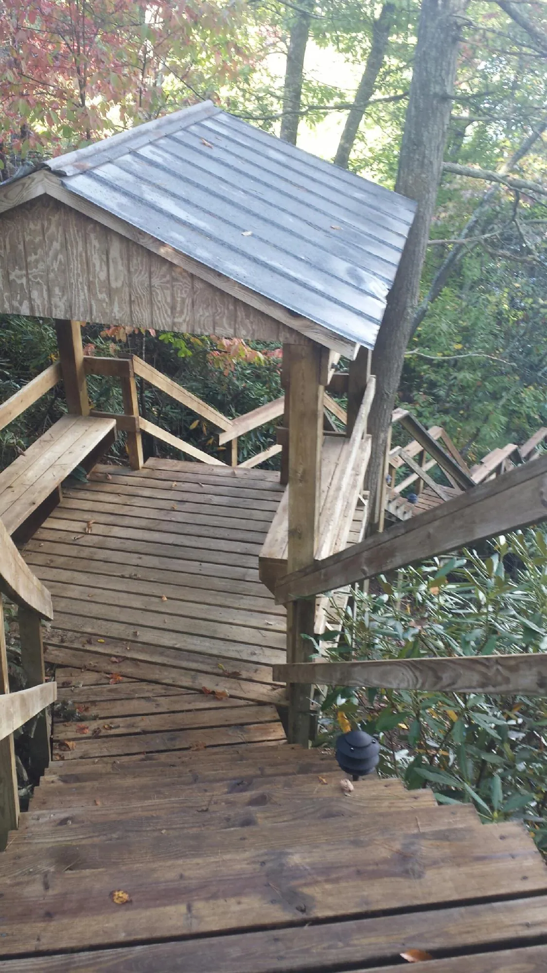 Metal roofed shelter over wooden steps on a wooded walkway — Skylight Repair & Installation work by our crew in Menomonee Falls