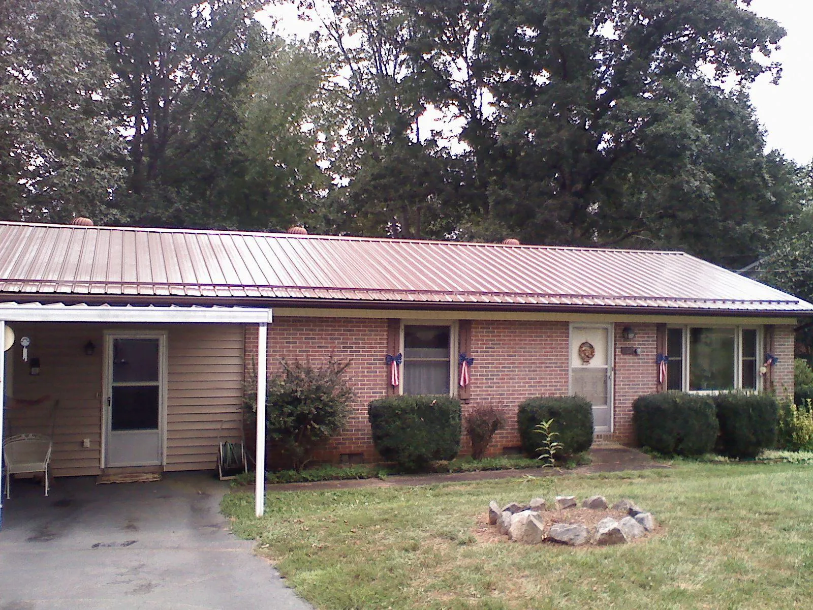 Bronze metal roof and carport on a brick ranch home — Roof Repair work by our crew in Menomonee Falls